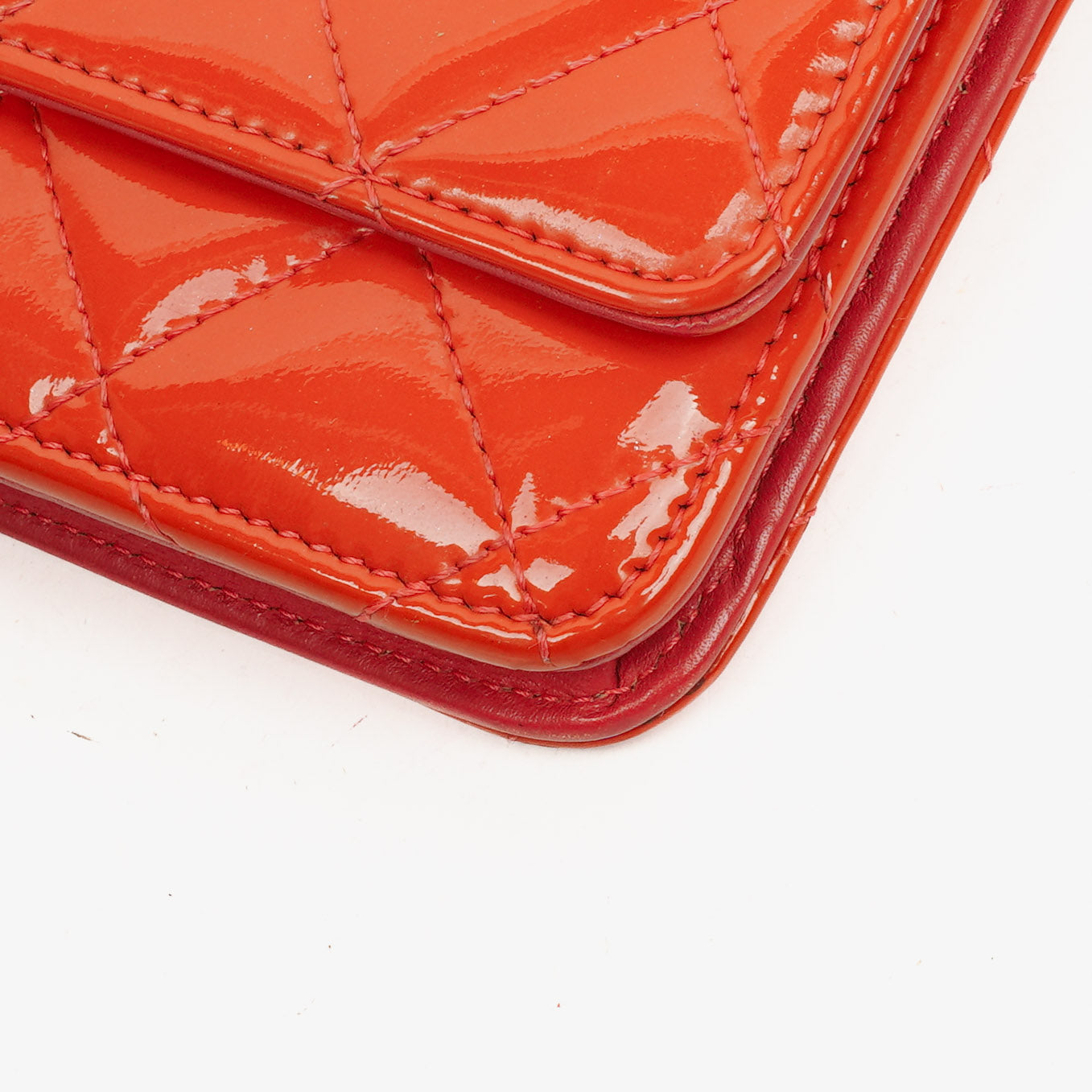 CHANEL Wallet on Chain WOC aus orangefarbenem gestepptem Lackleder mit pinkem CC-Logo und silberfarbenen Beschlägen