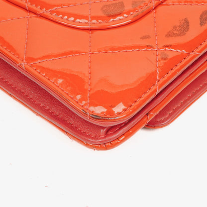 CHANEL Wallet on Chain WOC aus orangefarbenem gestepptem Lackleder mit pinkem CC-Logo und silberfarbenen Beschlägen