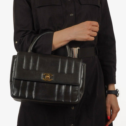 Chanel Kelly Flap Tasche aus schwarzem vertikal gestepptem Lammleder