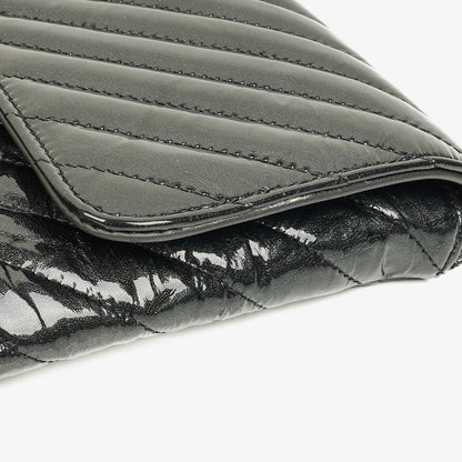 CHANEL Flap Clutch aus metallisch schwarzem geknittertem Lack-Kalbsleder mit Chevron-Steppung