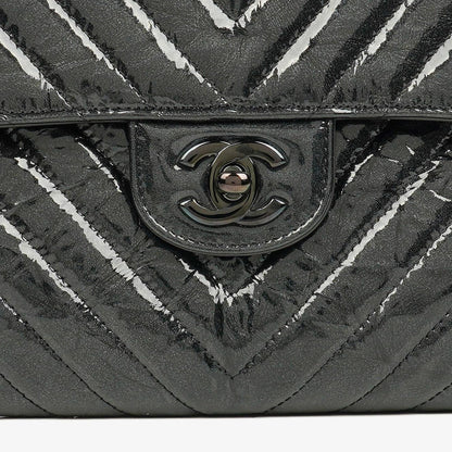 CHANEL Flap Clutch aus metallisch schwarzem geknittertem Lack-Kalbsleder mit Chevron-Steppung