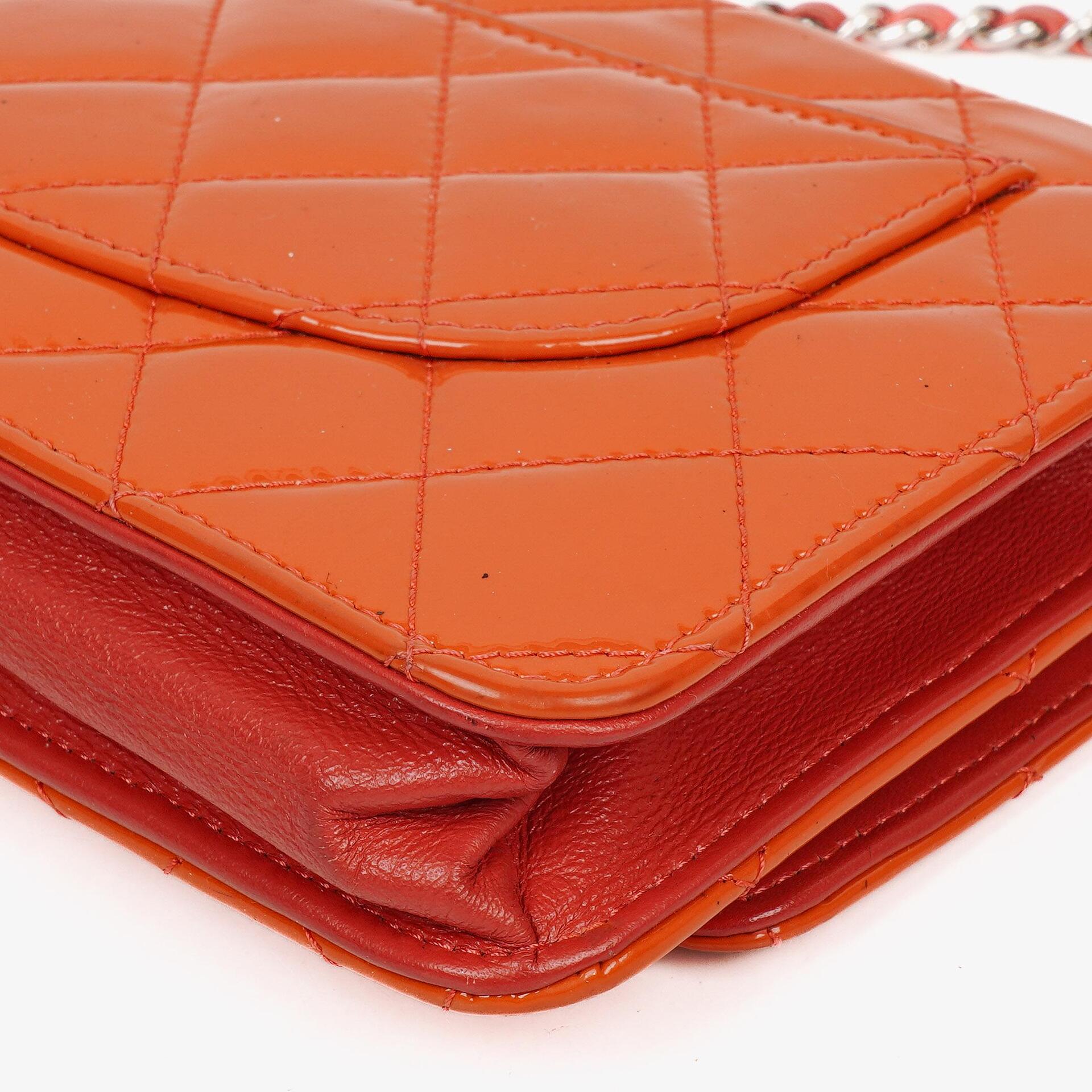 Chanel WOC Geldbörse mit Kette aus orange gestepptem Lackleder