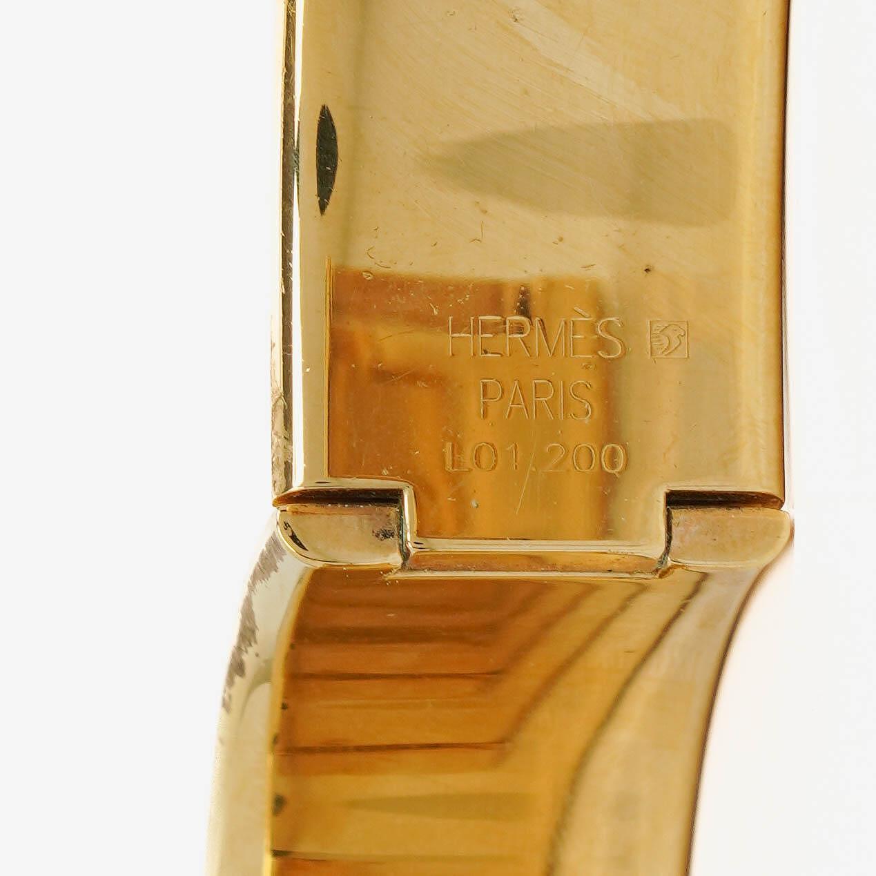 Hermès Loquet L01.201 Quarz-Armreifuhr mit roter Equestrian-Emaille und Vergoldung